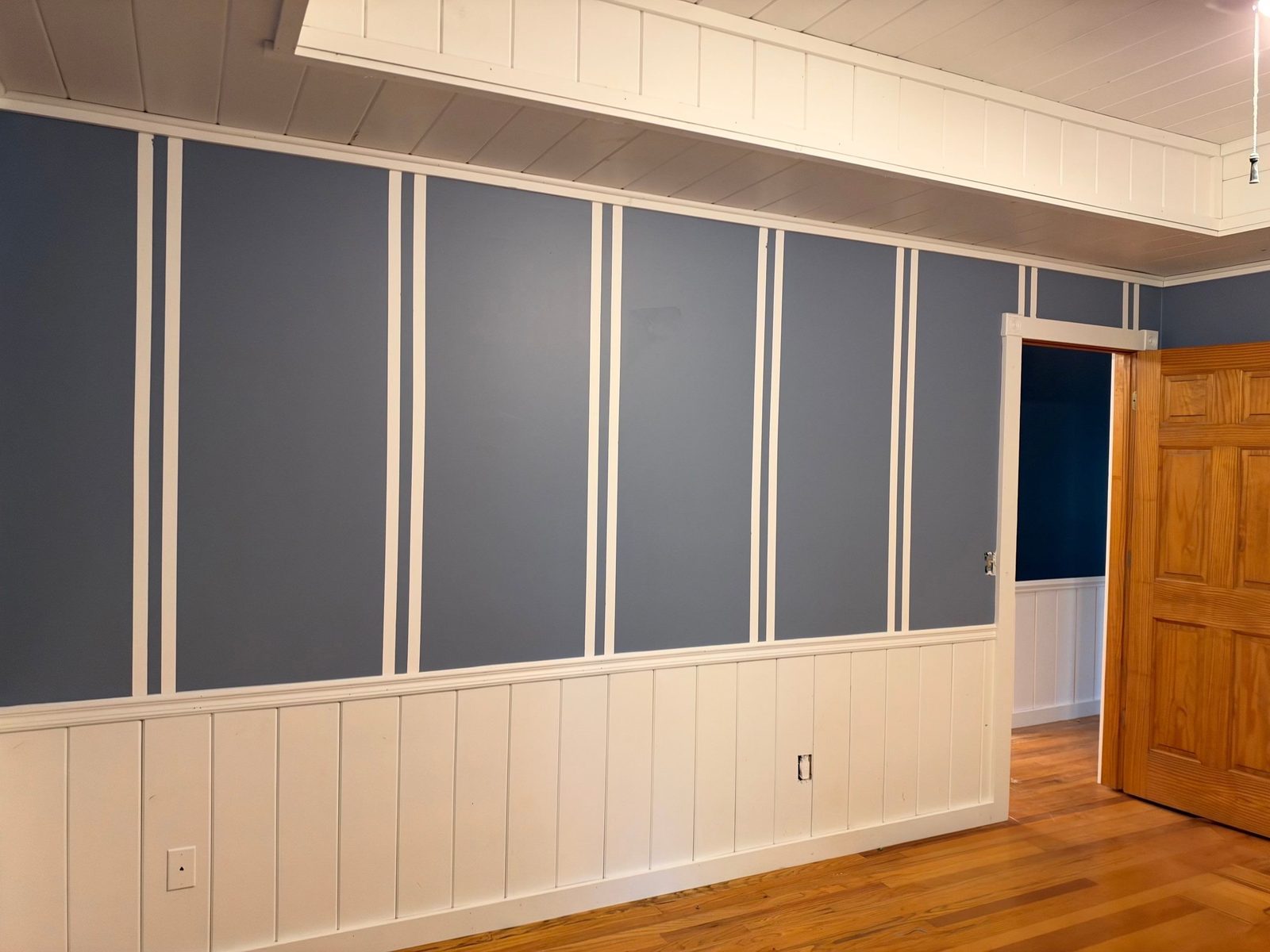 Blue-gray accent wall with white double board-and-batten strips in a Blue Ridge, GA cabin bedroom