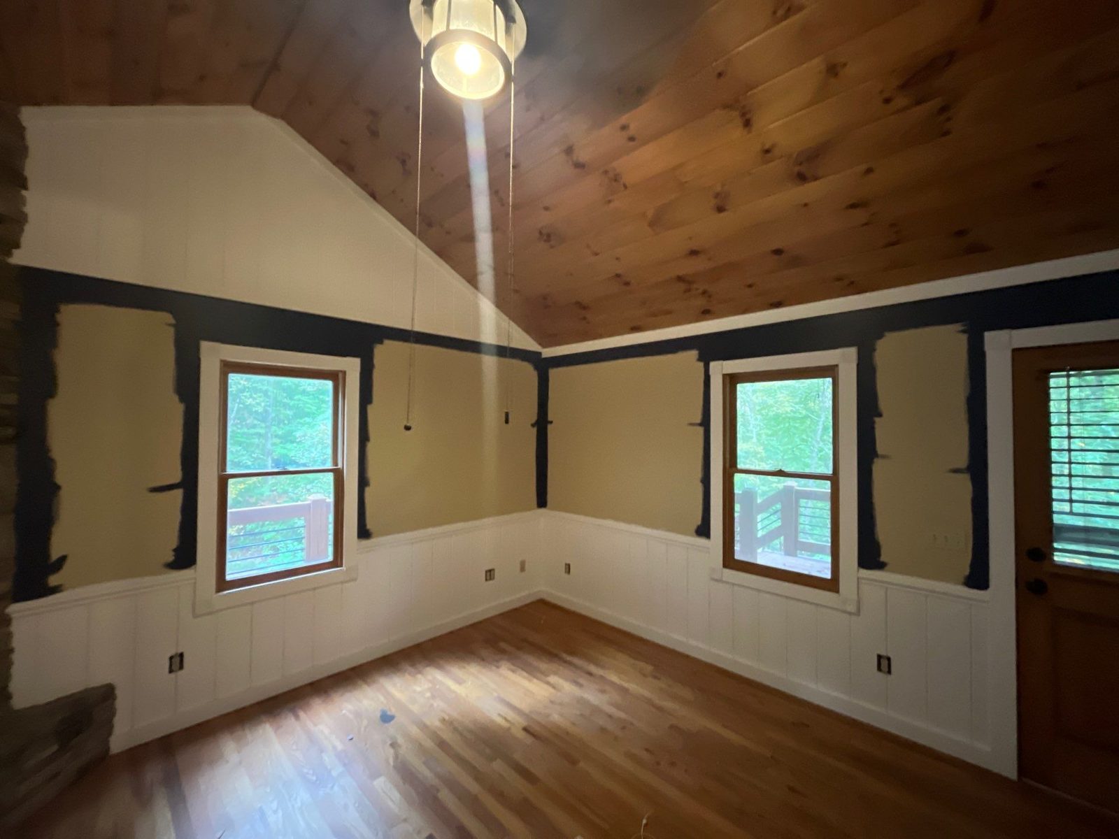 Blue Ridge cabin bedroom before painting, beige walls with navy cut in along the trim and ceiling line