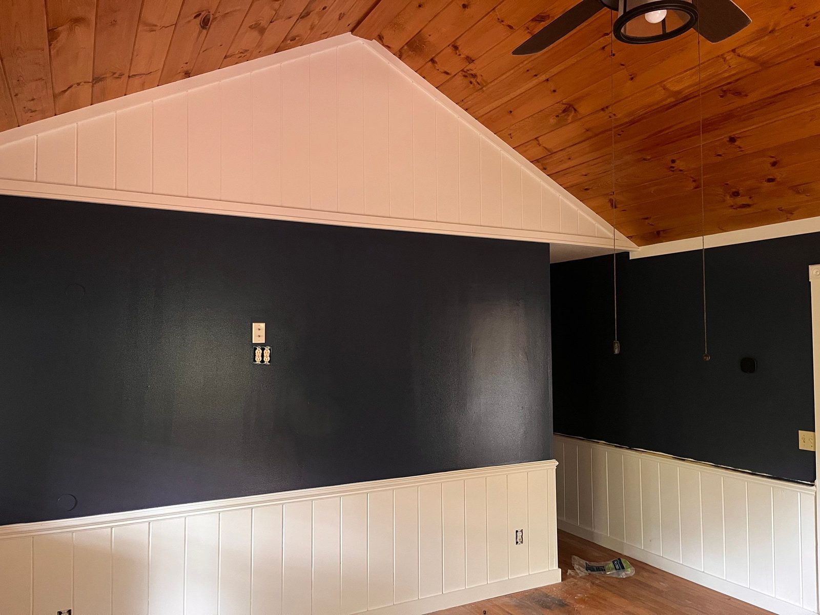 Navy painted cabin bedroom with a white gable wall and knotty pine vaulted ceiling in Blue Ridge, GA