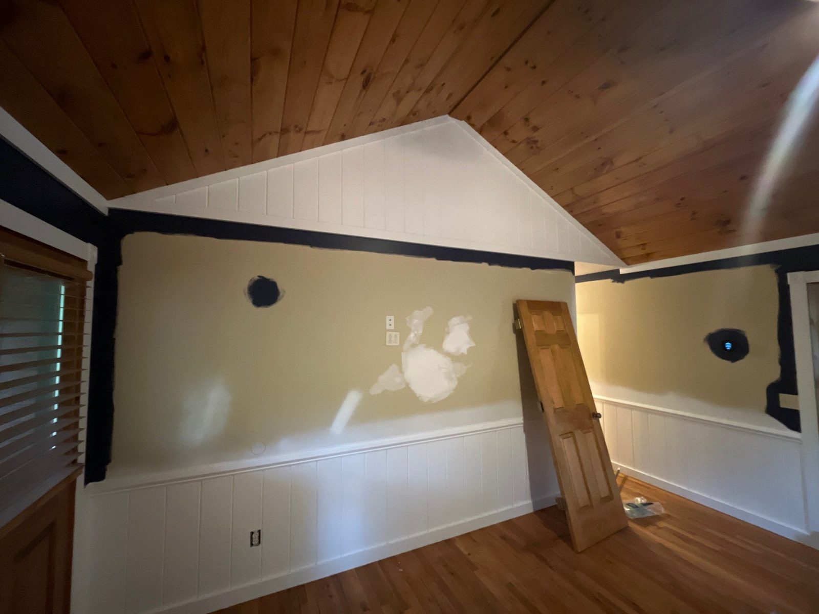 Patched beige bedroom walls in a Blue Ridge, GA cabin before the navy paint went on