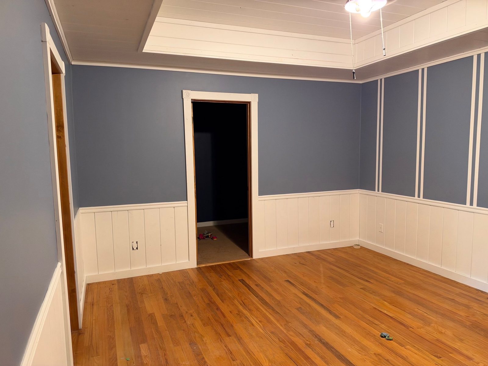 Blue-gray cabin bedroom with white wainscot and a white tray ceiling in Blue Ridge, GA