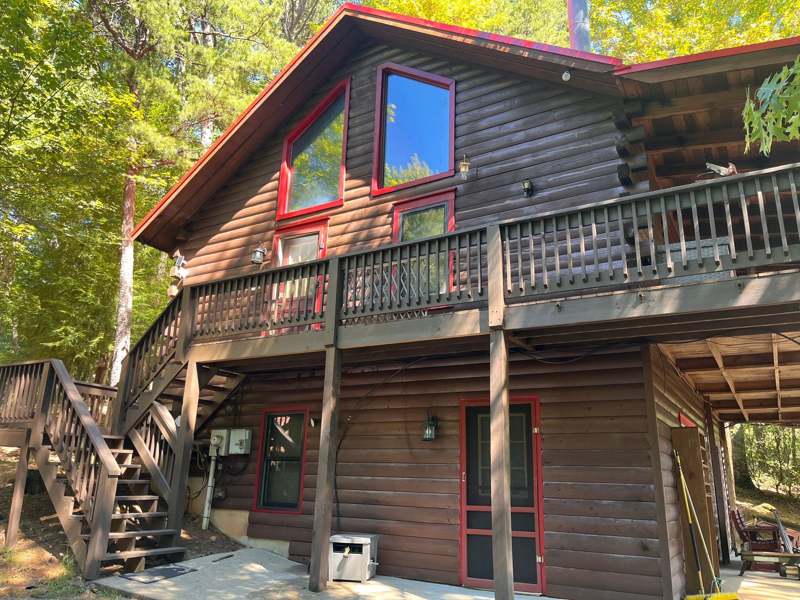 Back of a Cherry Log, GA log cabin after staining, with deck stairs and red trim