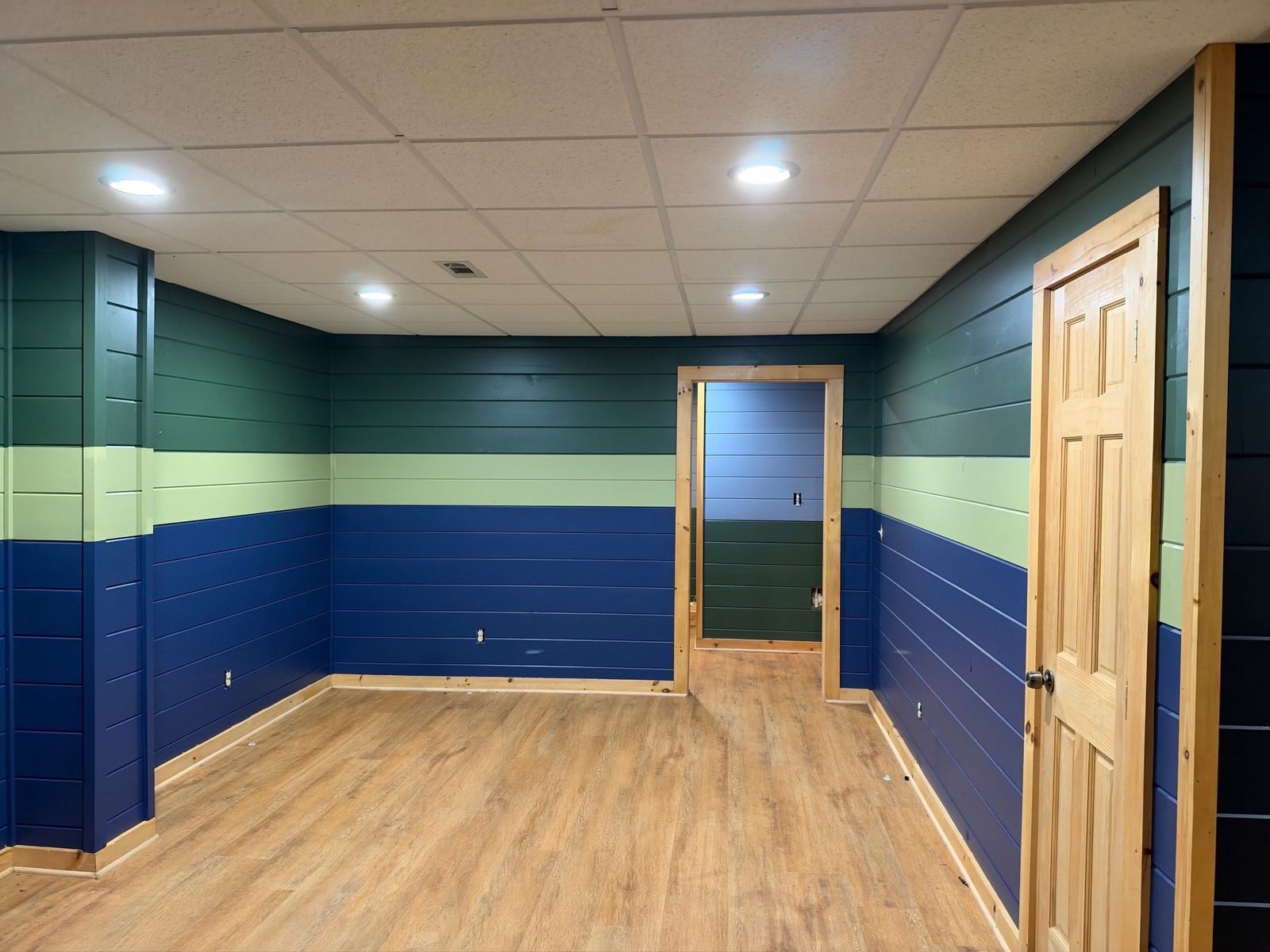 Painted basement shiplap in three bands, forest green, sage and navy, in a Blue Ridge, GA cabin
